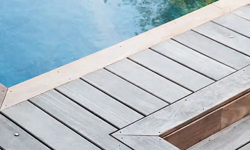 Détail de la margelle en bois exotique d’une piscine sur-mesure réalisée par Nymfeo