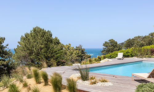 Piscine moderne entourée de végétation avec vue mer à Erquy – Conception paysagère par Nymfeo