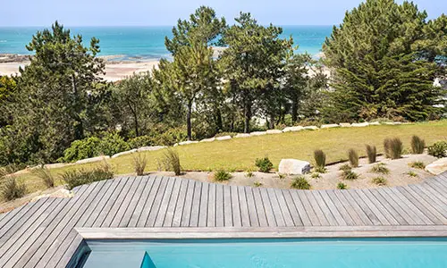 Vue sur la mer depuis une terrasse en bois avec piscine à Erquy – Aménagement extérieur réalisé par Nymfeo